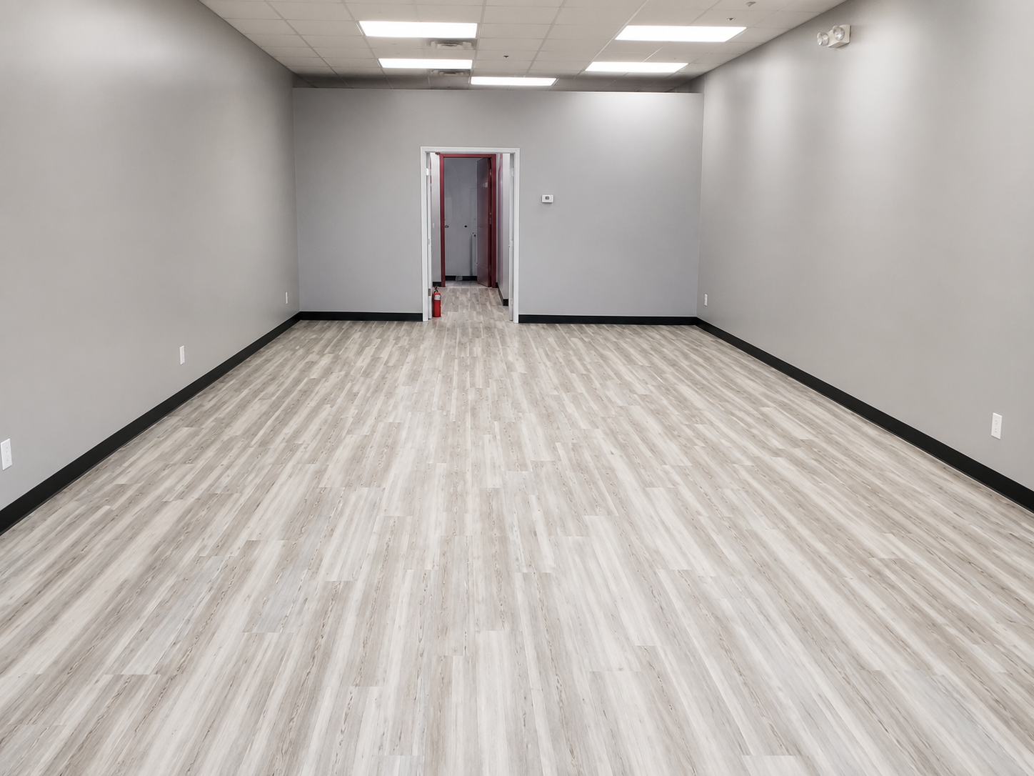 Gray vinyl plank flooring in an empty commercial space