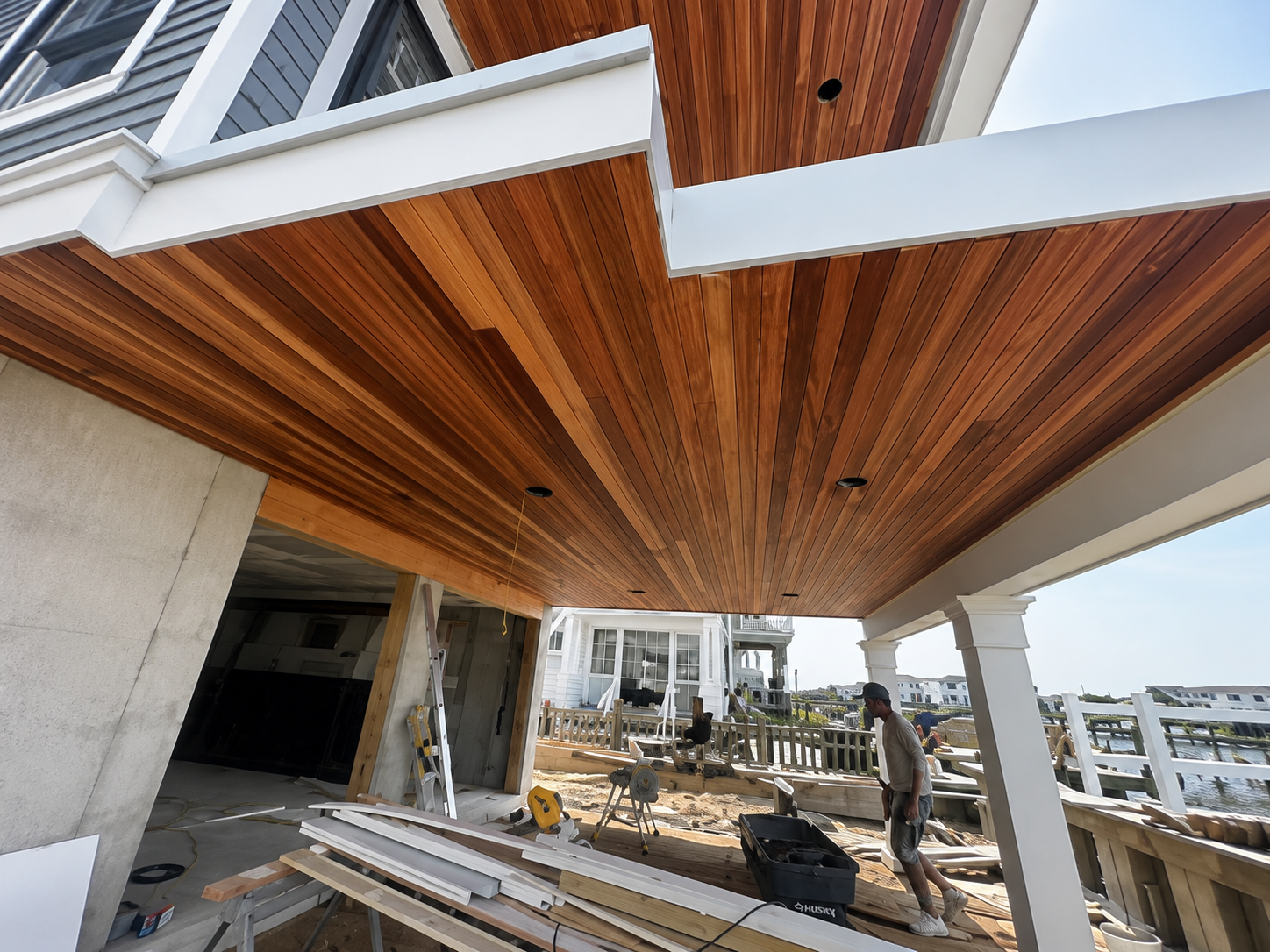 Stained wood porch ceiling in progress on a waterfront home