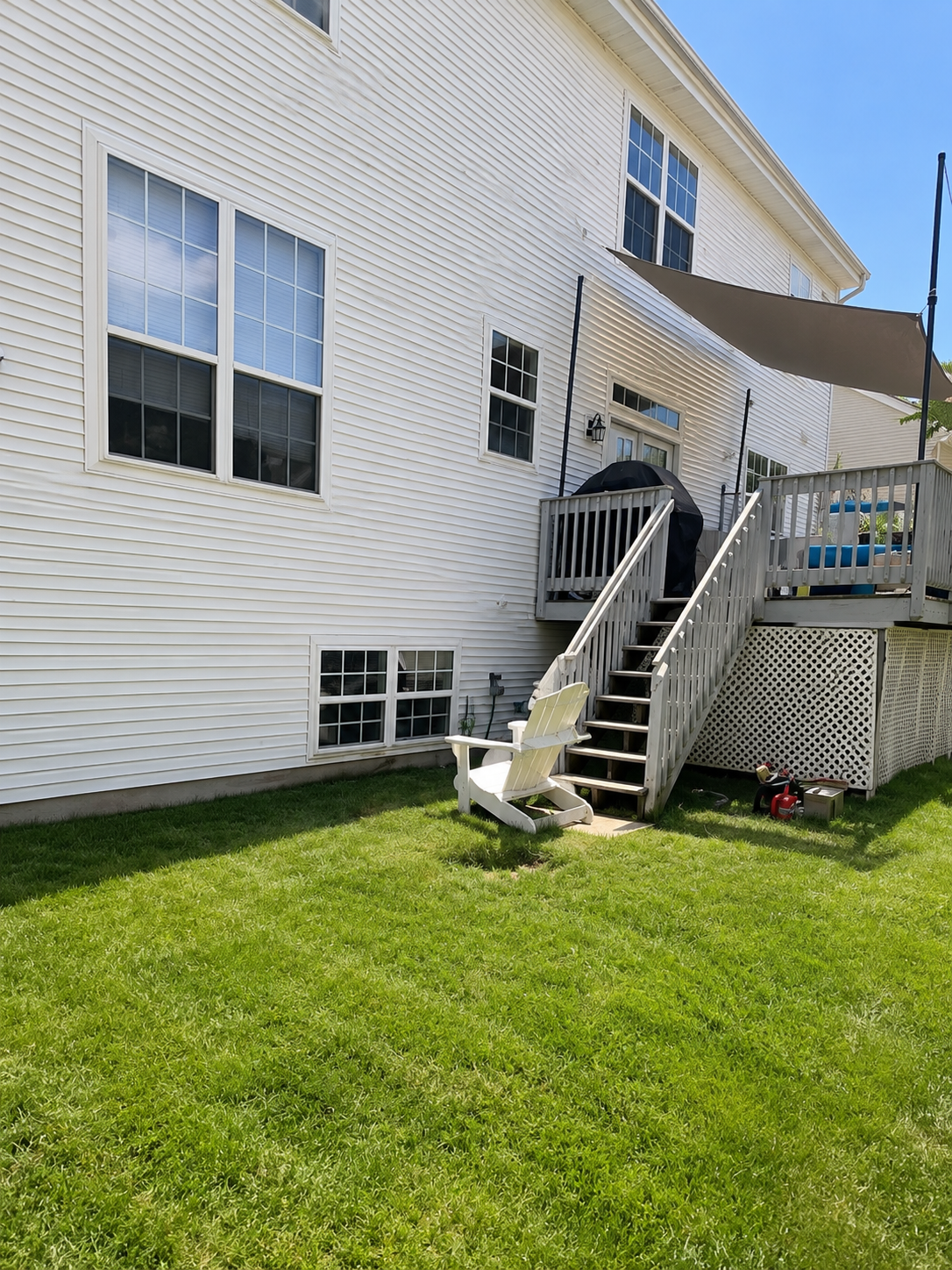 Rear yard with deck and stairs on a white-sided home